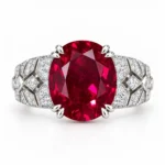 Oval red gemstone ring with paired prongs and sparkling geometric shoulders