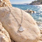 Ginkgo Glow fan pendant necklace in a styled jewelry display