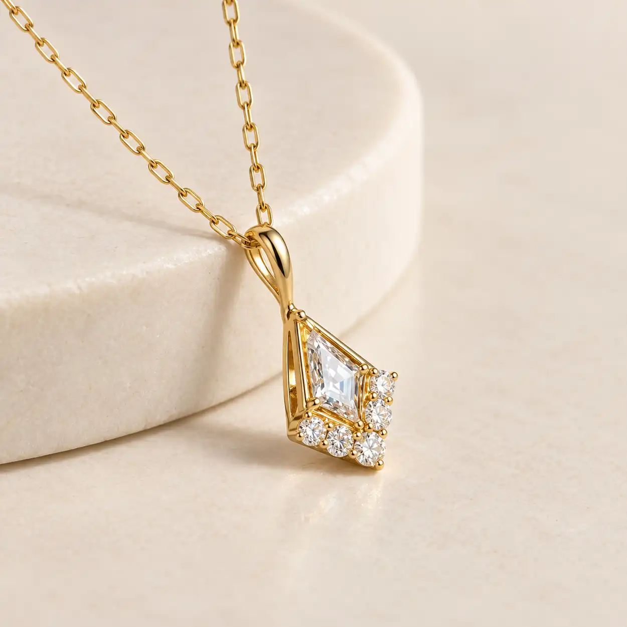 Close-up of the kite-shaped center stone, round accents and curved gold-plated bail