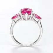 Side profile of the pink three-stone ring showing the prong settings and silver band
