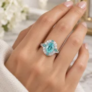 Model wearing an oval blue-green gemstone statement ring