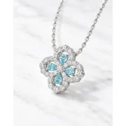 Angled view of the Ocean Luck clover pendant showing blue teardrop stones and scalloped borders