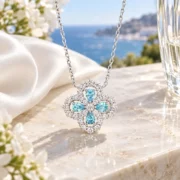 Side profile of the blue clover pendant showing its silver setting and chain connections