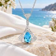 Ocean Reverie blue topaz fan pendant and delicate silver chain arranged in an elegant jewelry display