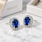 45-degree view of Royal Bloom sapphire stud earrings showing the oval halos and raised prong settings