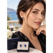 Close-up of a model wearing a Royal Bloom sapphire halo stud earring in sterling silver