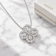 45-degree view of the Luminous Luck clover necklace showing its pear-shaped stones and scalloped borders