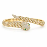 Golden Instinct snake bangle bracelet with clear pavé stones and a green eye detail