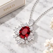 45-degree view of the Crimson Flame ruby pendant showing its raised oval center and mixed-shape halo