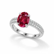 Angled view of the Crimson Devotion ring showing its red oval center and pavé shoulders