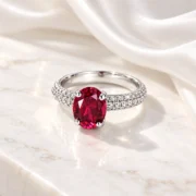 Side profile of the oval red diamond ring showing the prong setting and silver band