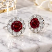 45-degree view of Crimson Blossom ruby earrings showing their scalloped halos and prong settings