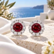 Crimson Blossom round ruby earrings with sparkling floral halos arranged in an elegant jewelry display