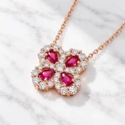 45-degree view of the Crimson Wish ruby clover necklace showing its red stones and delicate openwork setting