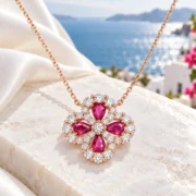 Crimson Wish ruby clover pendant and fine gold-tone chain arranged in an elegant jewelry display