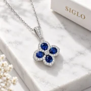 45-degree view of the Blue Fortune sapphire clover pendant showing its individual halos and stone-set bail