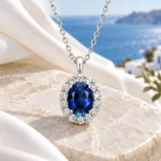 Classic Blue oval sapphire pendant and fine silver chain arranged in an elegant jewelry display