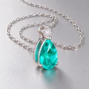 Angled view of the pear-shaped blue-green pendant and silver prong setting