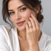 Silver rose ring with a pink center displayed on a warm wooden surface
